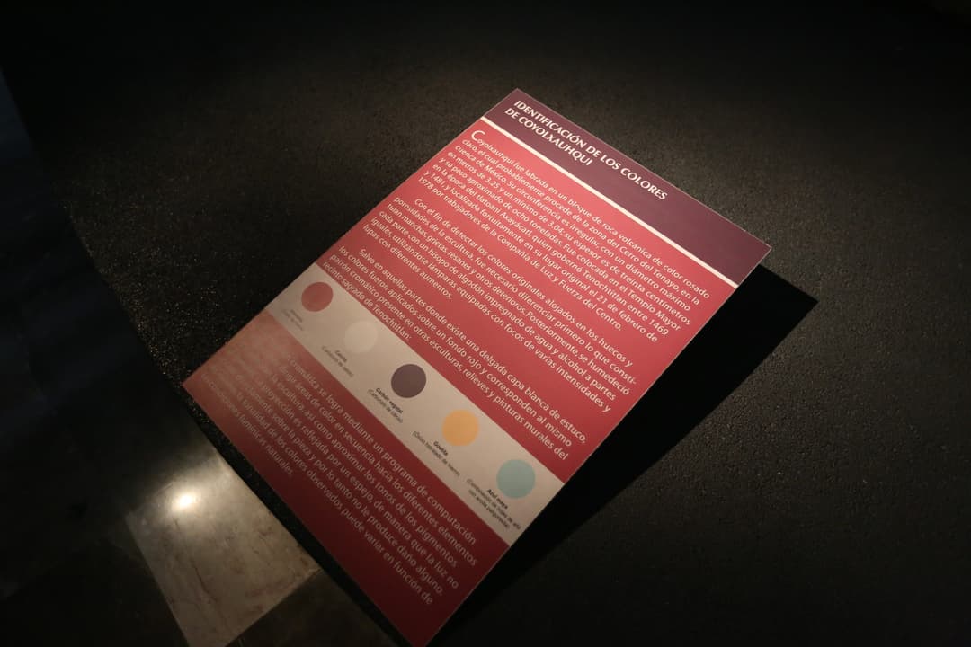 Museum display plaque detailing color identification on Coyolxauhqui.