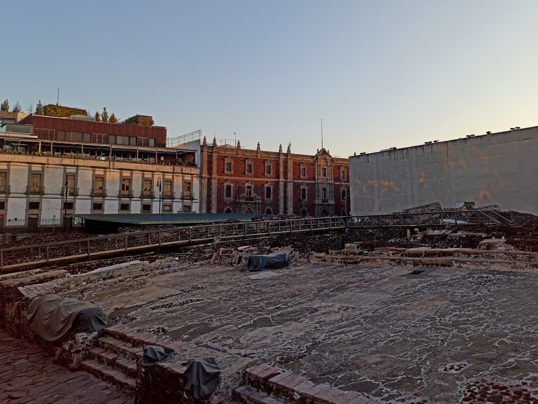 Templo Mayor archaeological ruins and historic buildings at twilight.