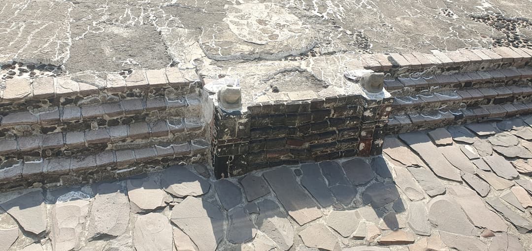 Excavated stone steps and flagstone paving at Templo Mayor in bright daylight.