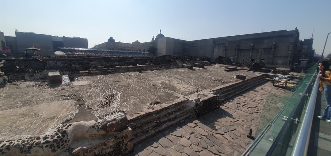 Wide-angle view of stone platforms and serpent heads at Templo Mayor.