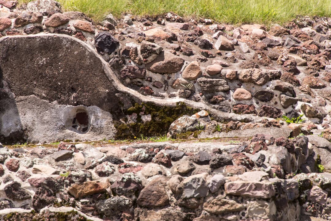 Close-up of stone masonry and stucco remnants at Teotihuacan in daylight.