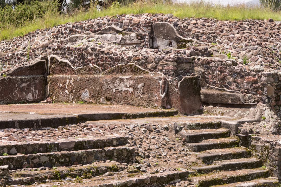 Detail of ancient stone steps and masonry platforms in daylight.