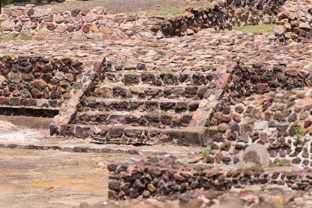 Detail of ancient stone steps and masonry platforms in bright daylight.