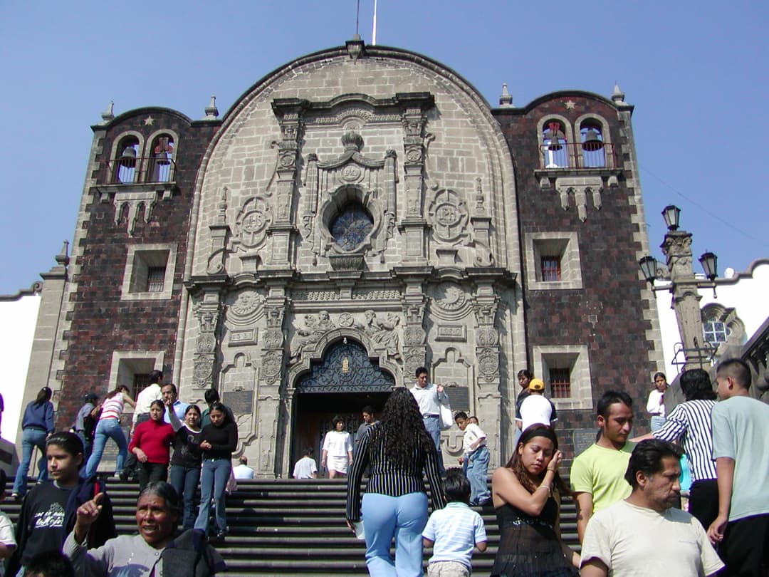 Front view of the Capilla del Cerrito facade and entrance steps in daylight.