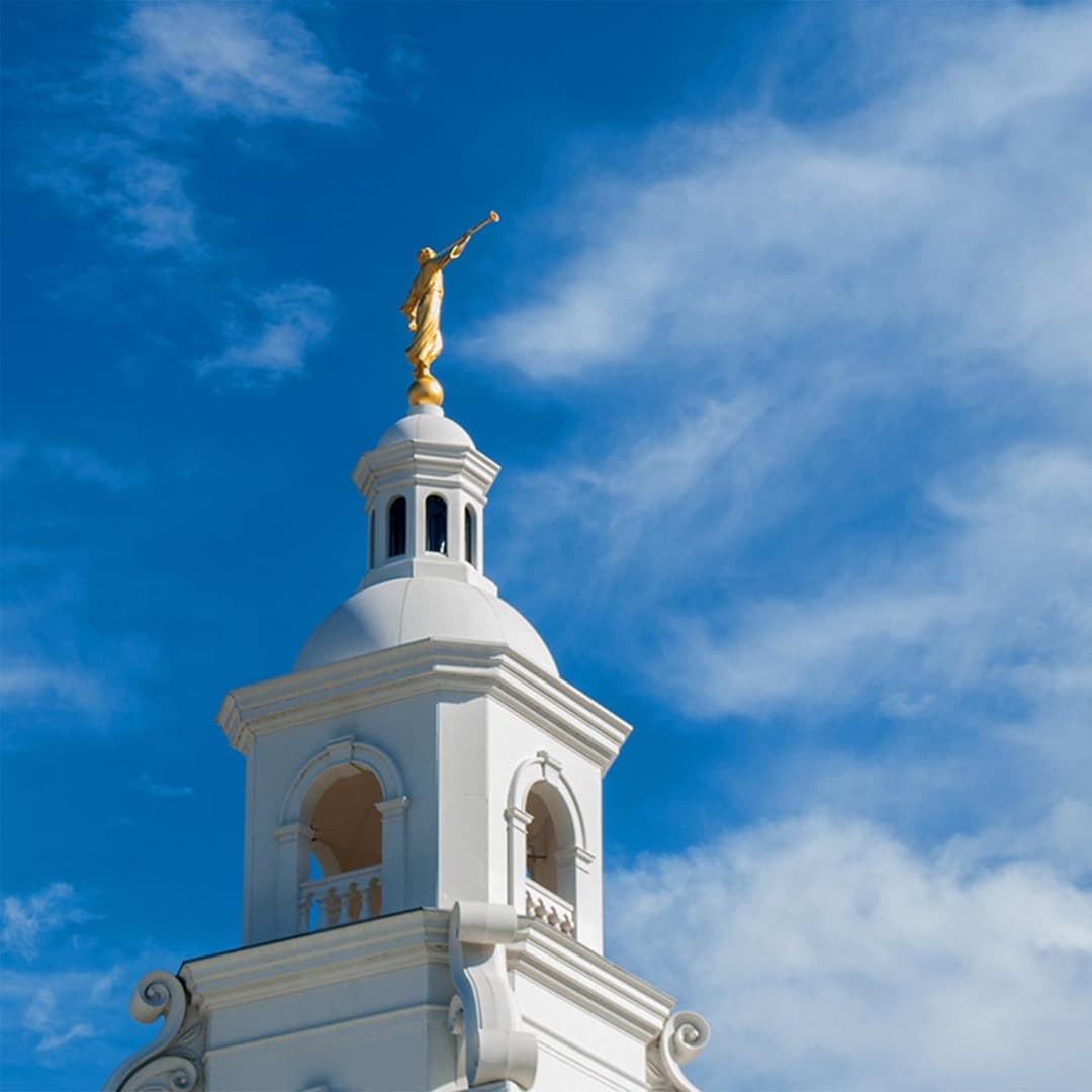 Low-angle view of the white spire and golden Angel Moroni statue.