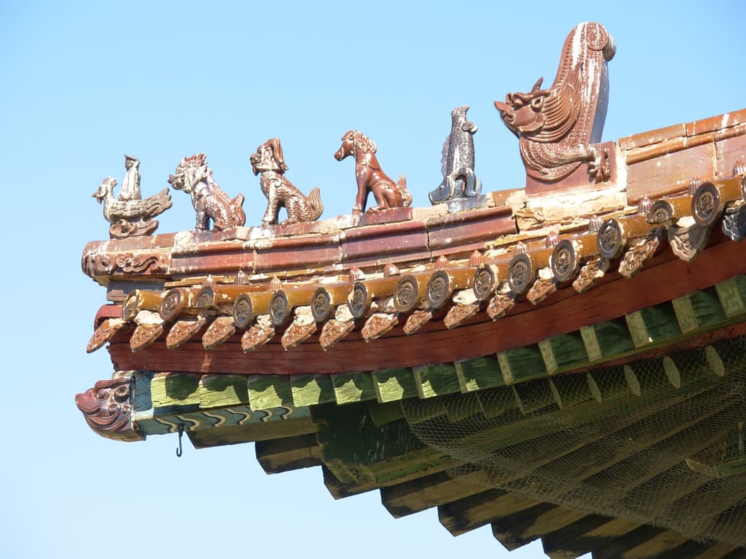 Detail of ornamental glazed ceramic roof figurines on a corner eave.
