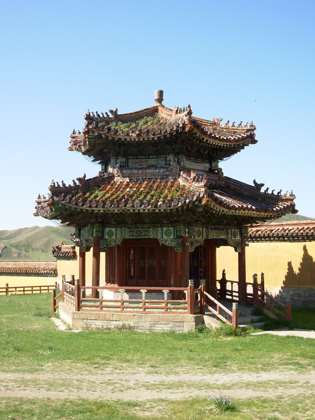 Exterior view of a double-roofed wooden pavilion on the monastery grounds.