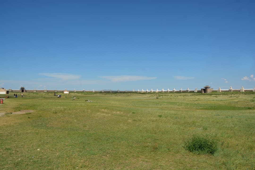 Wide-angle view of the grassy grounds and stupa-studded perimeter wall.