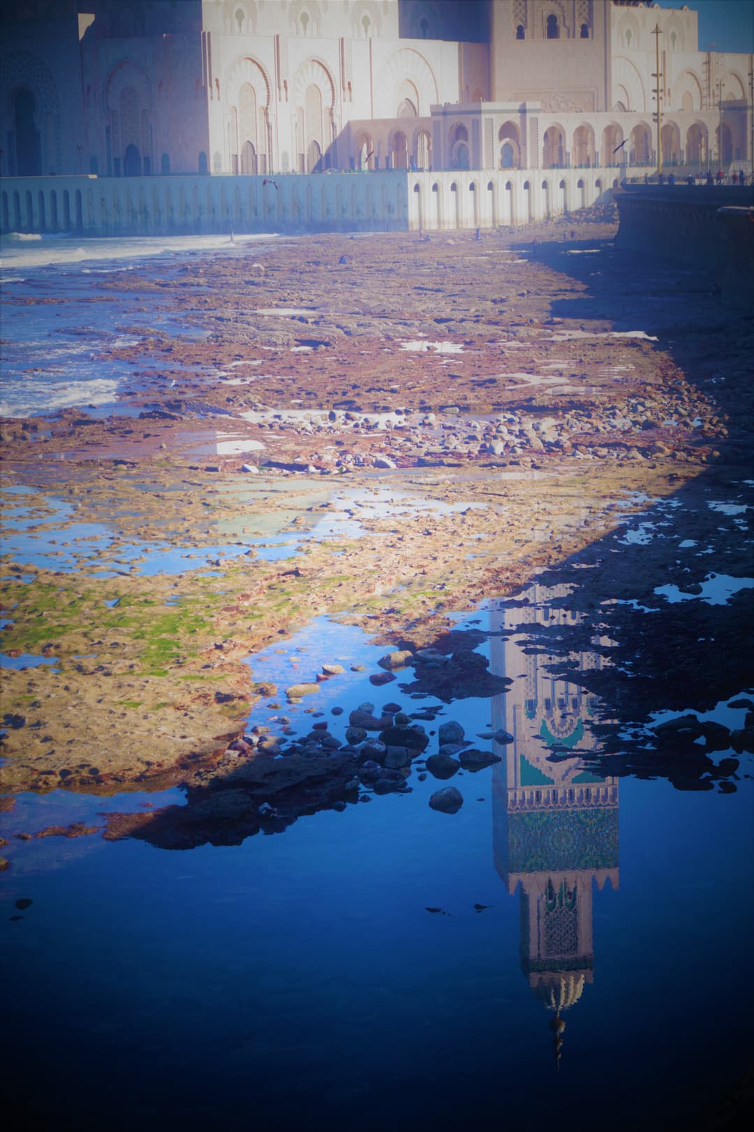 Reflection of the Hassan II Mosque minaret in coastal tide pools