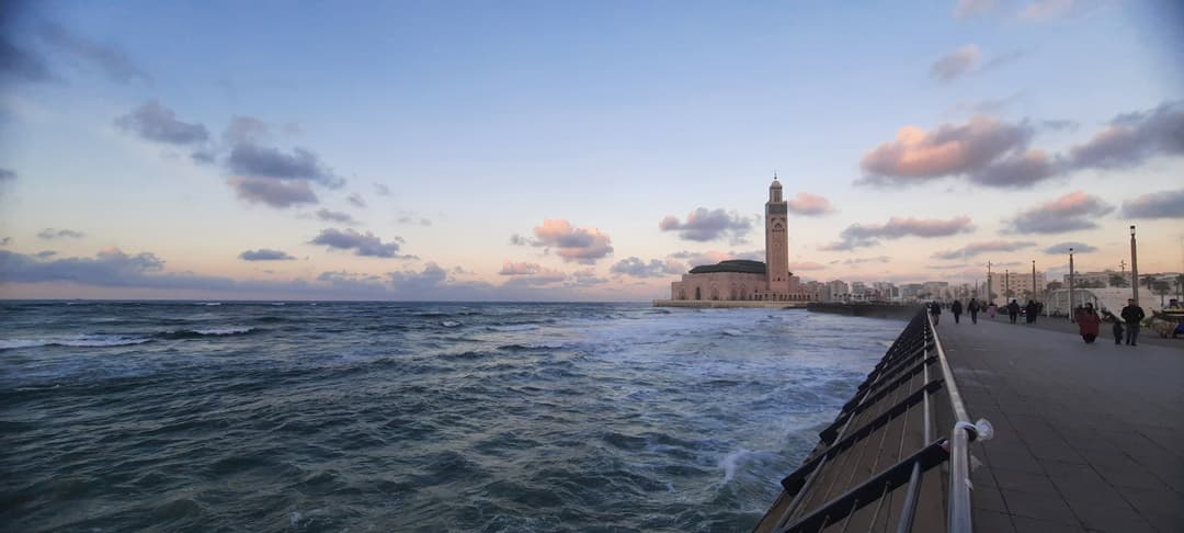 Hassan II Mosque viewed from the coastal promenade at sunset