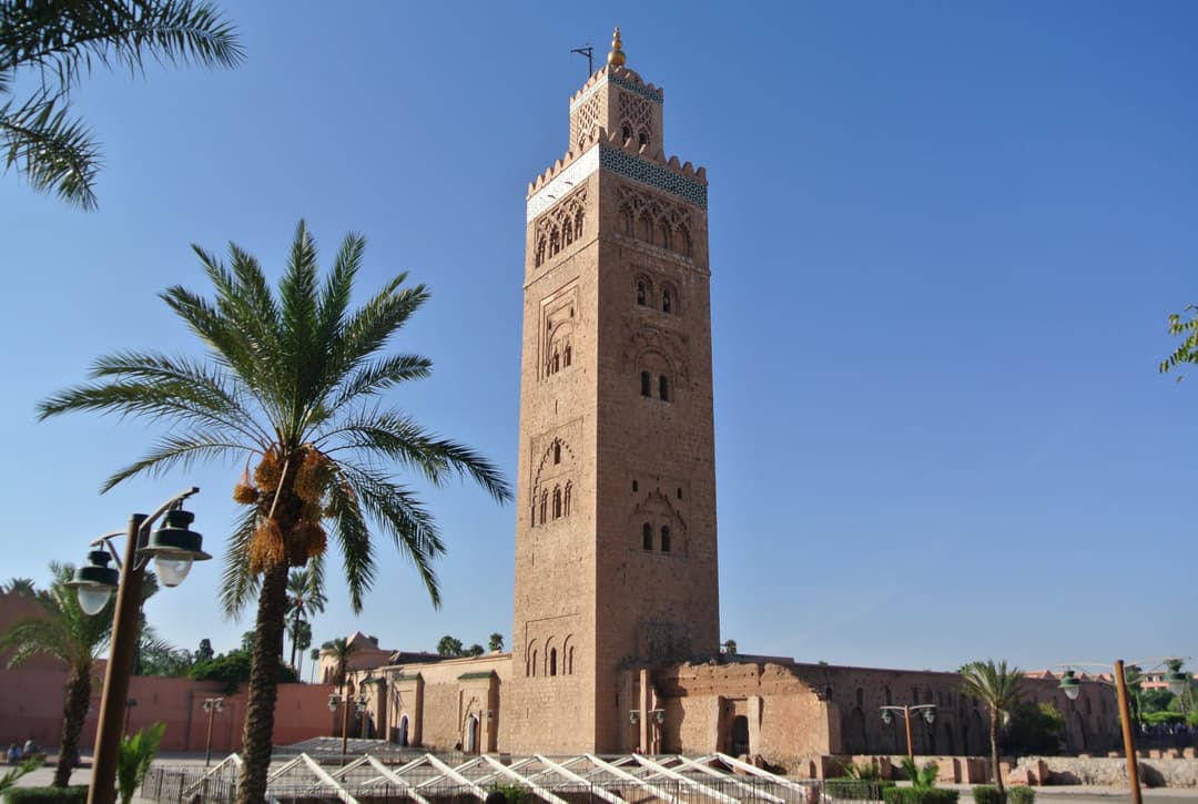 Koutoubia Mosque minaret and palm tree under a clear blue sky