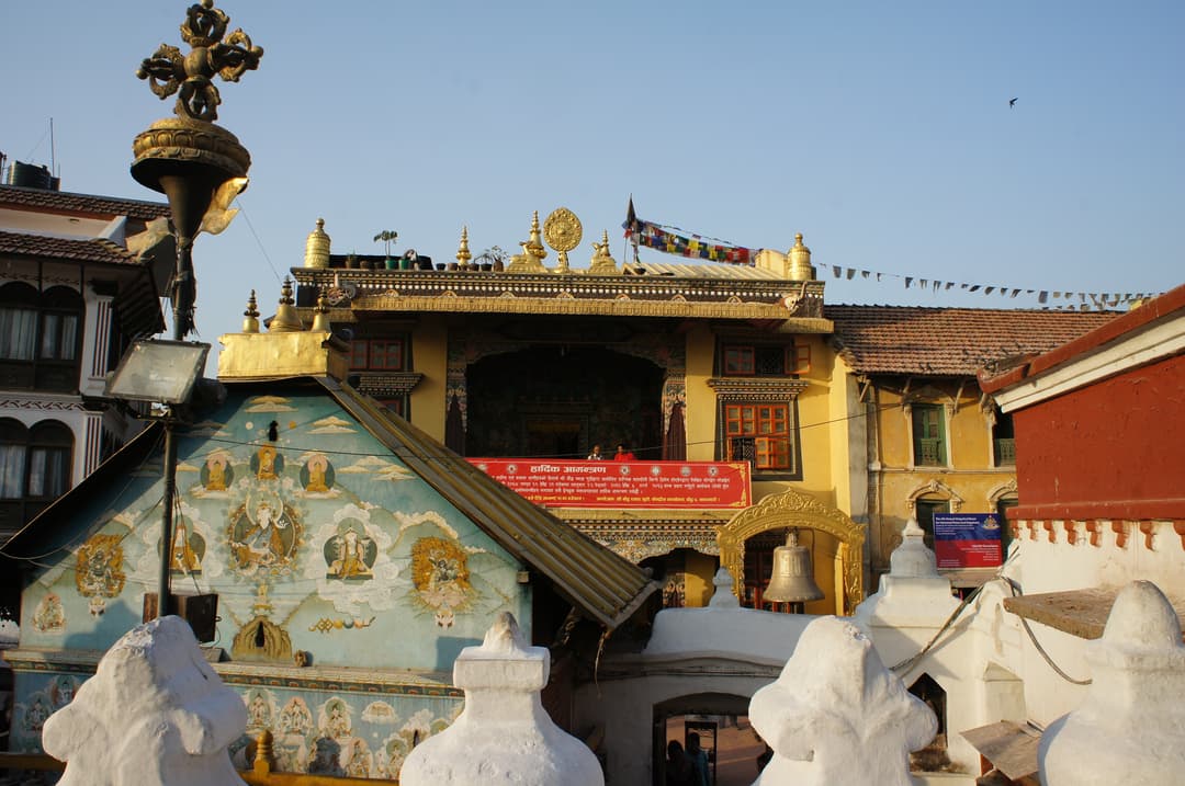 Monastery buildings and painted shrines surrounding Boudhanath Stupa.