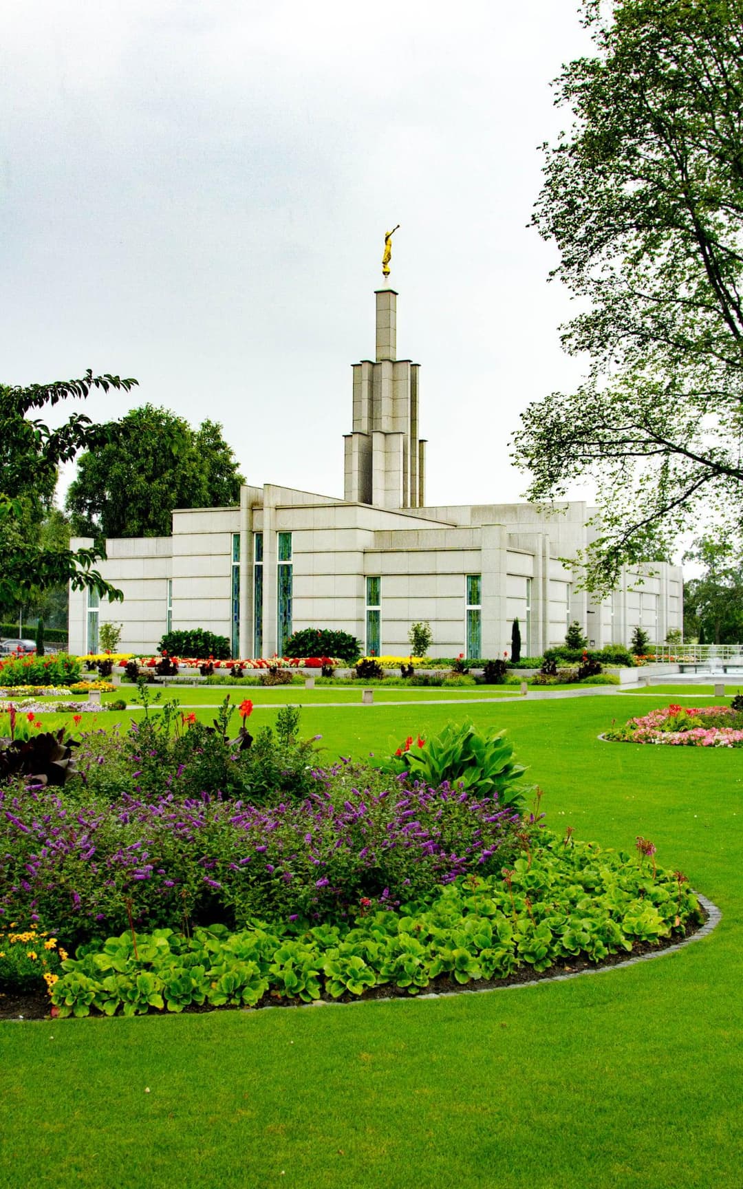 Exterior view of The Hague Netherlands Temple and landscaped grounds in daytime.