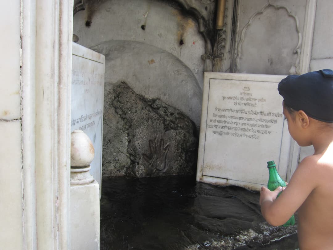 Guru Nanak's sacred handprint on the boulder at Gurdwara Panja Sahib