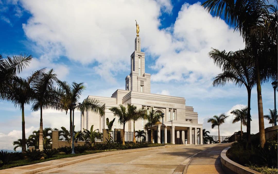 Wide exterior view of Panama City Panama Temple with spire and palm trees.