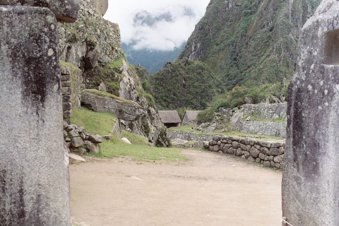 View through a stone portal towards Inca terraces and mountain peaks