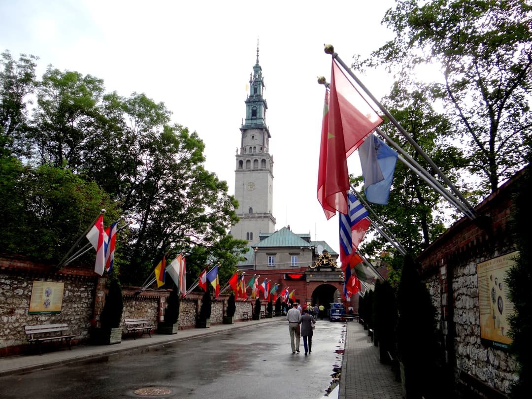 Flag-lined entrance avenue leading toward the Jasna Góra bell tower.