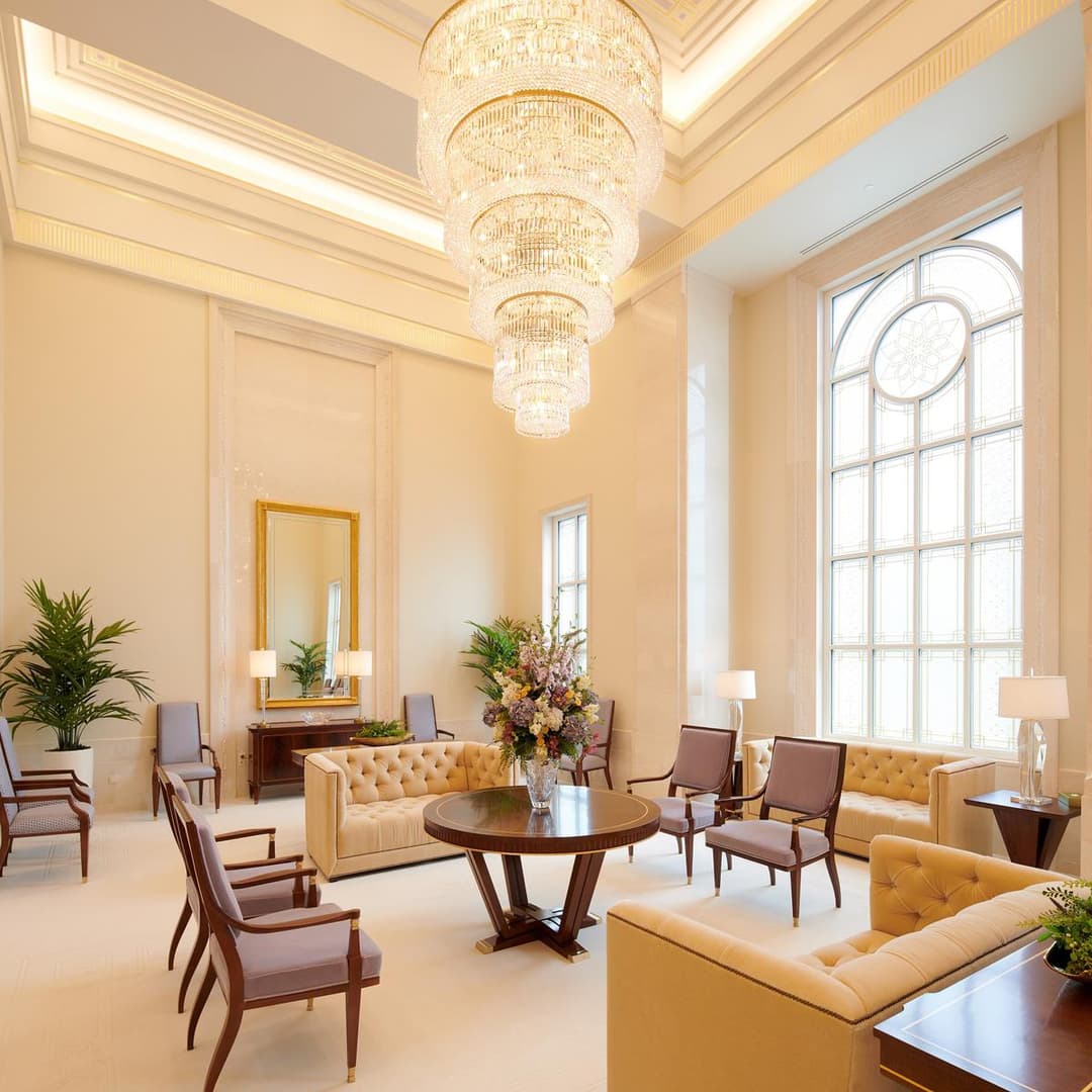Lisbon Temple interior: grand chandelier, elegant seating, and arched window.