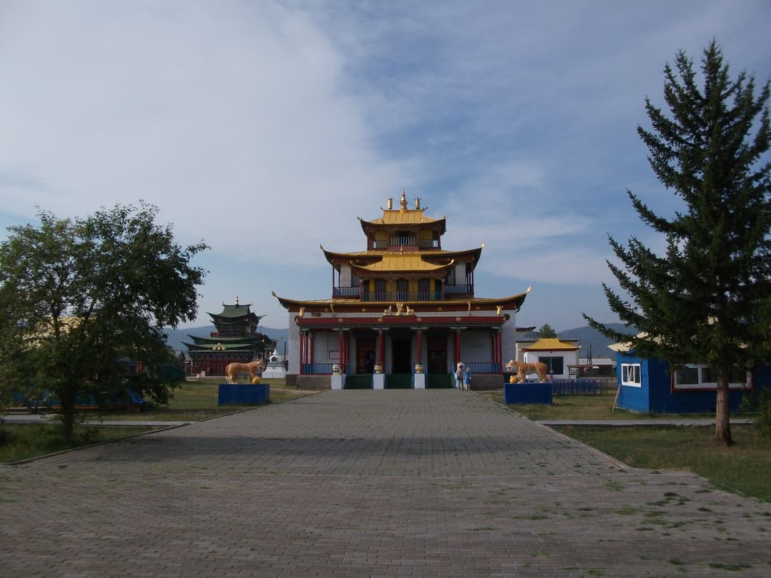 Frontal view of the golden-roofed temple and paved approach path.