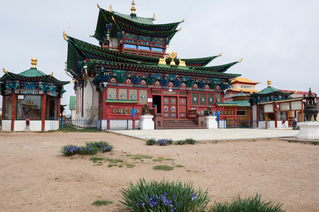 Exterior view of the ornate Sogchen Dugan with wild irises in foreground.