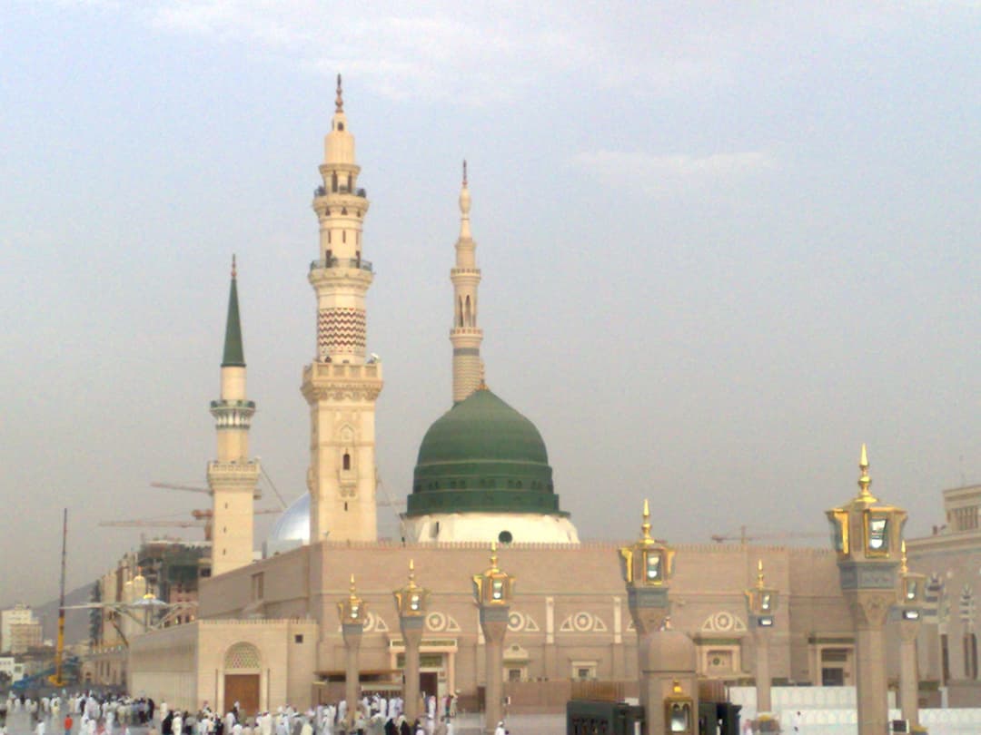 The Prophet's Mosque illuminated at night, showcasing its stunning architecture.