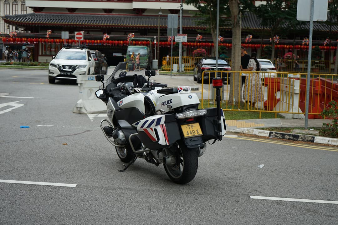 Street view of Buddha Tooth Relic Temple behind a parked police motorcycle.