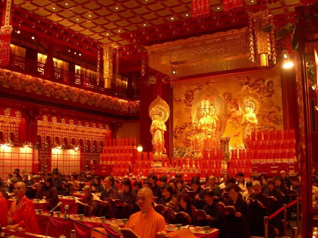 Interior of the main shrine hall during a Buddhist prayer service.