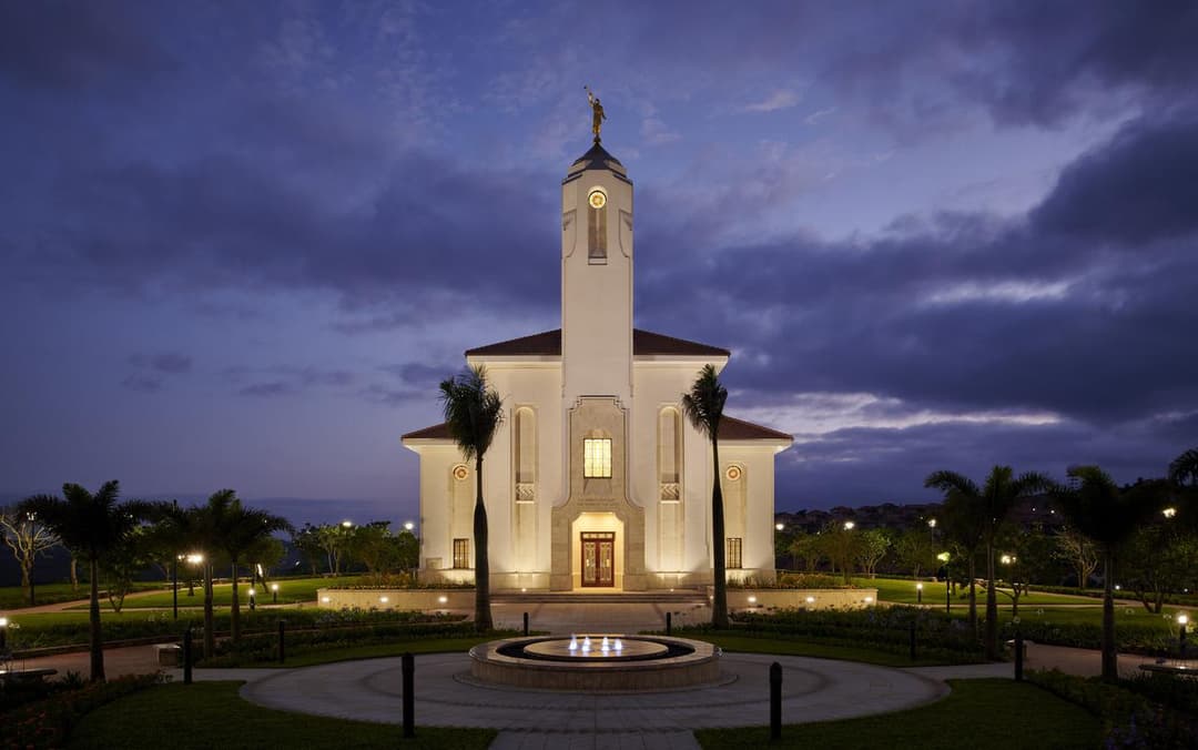 Durban South Africa Temple exterior at twilight, featuring Angel Moroni and fountain.