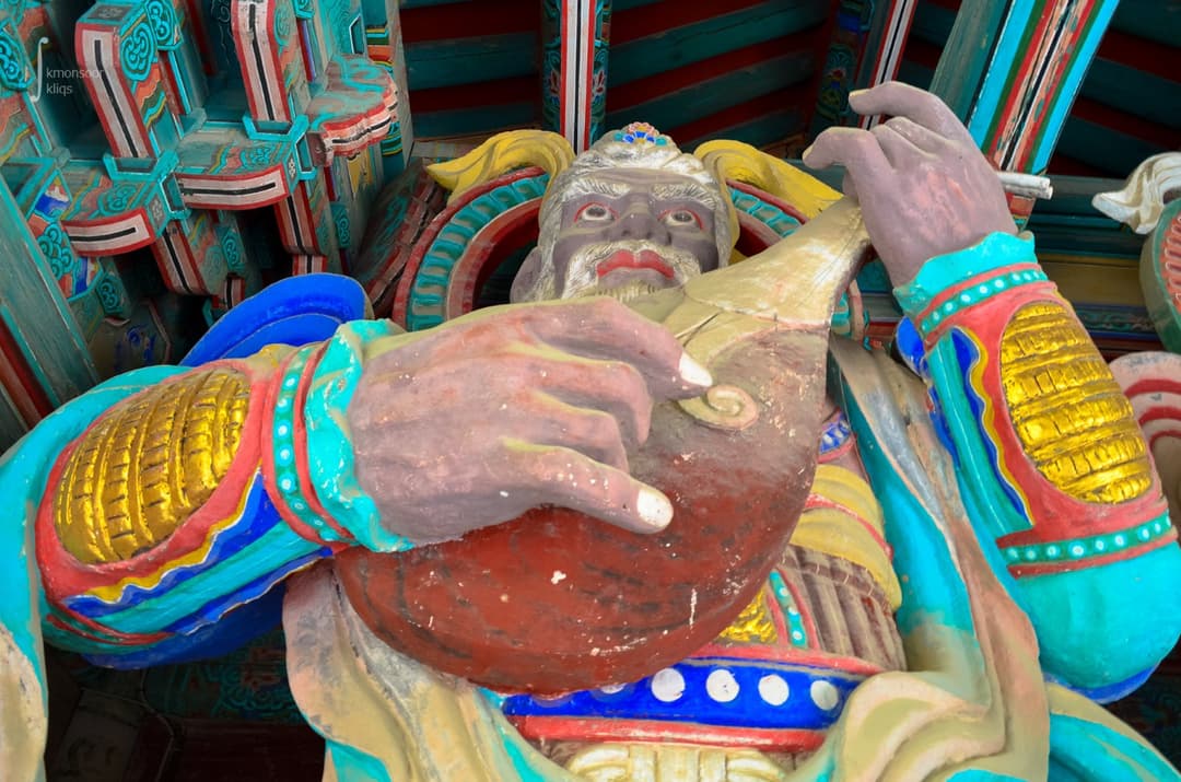 Close-up of the Four Heavenly Kings statue holding a lute inside Cheonwangmun.