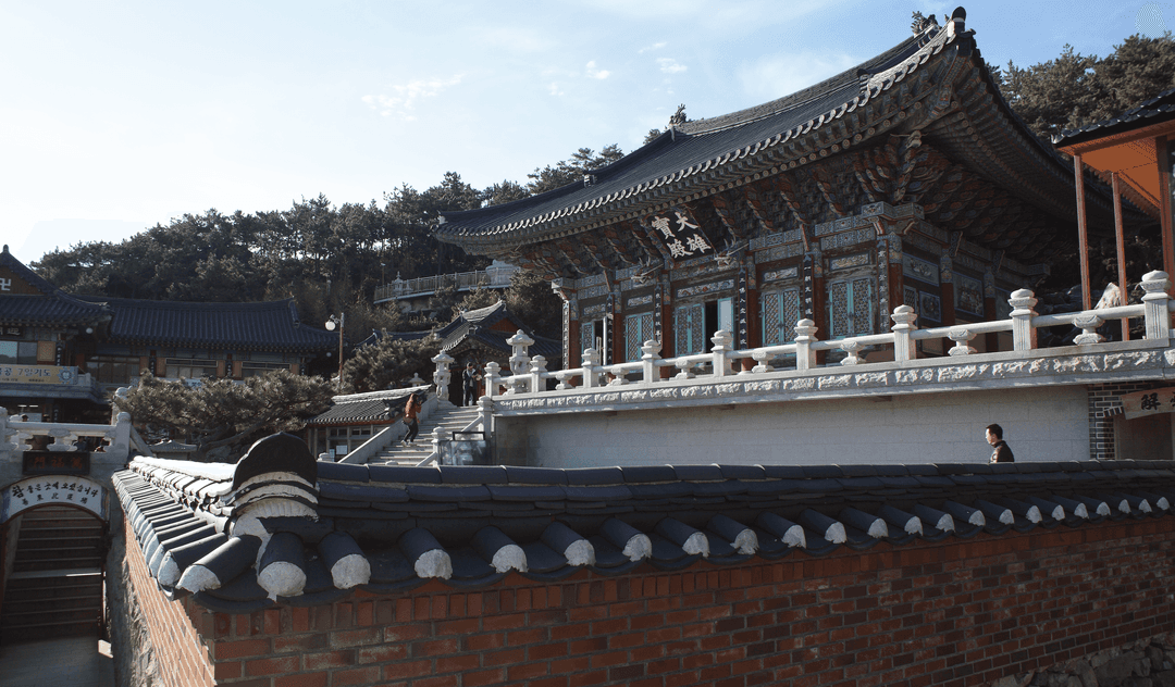 Exterior view of Daeungjeon Main Hall behind a traditional tiled wall.