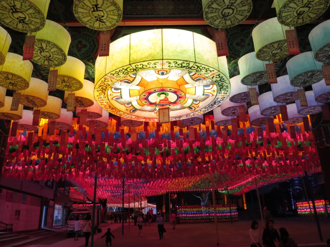 Vibrant lotus lanterns suspended over Jogyesa Temple courtyard at night.