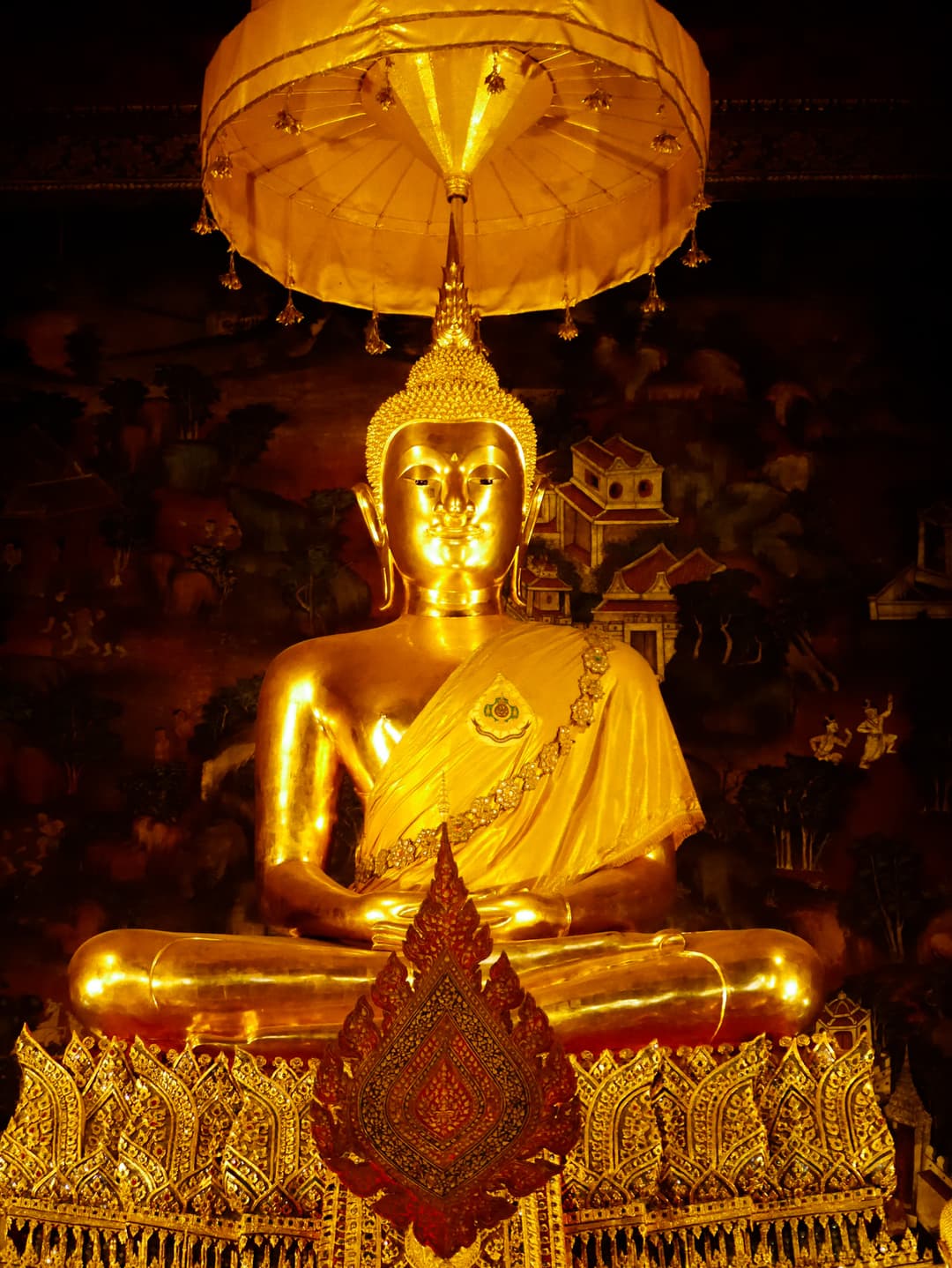 Golden seated Buddha statue inside the Uposatha hall at Wat Pho.