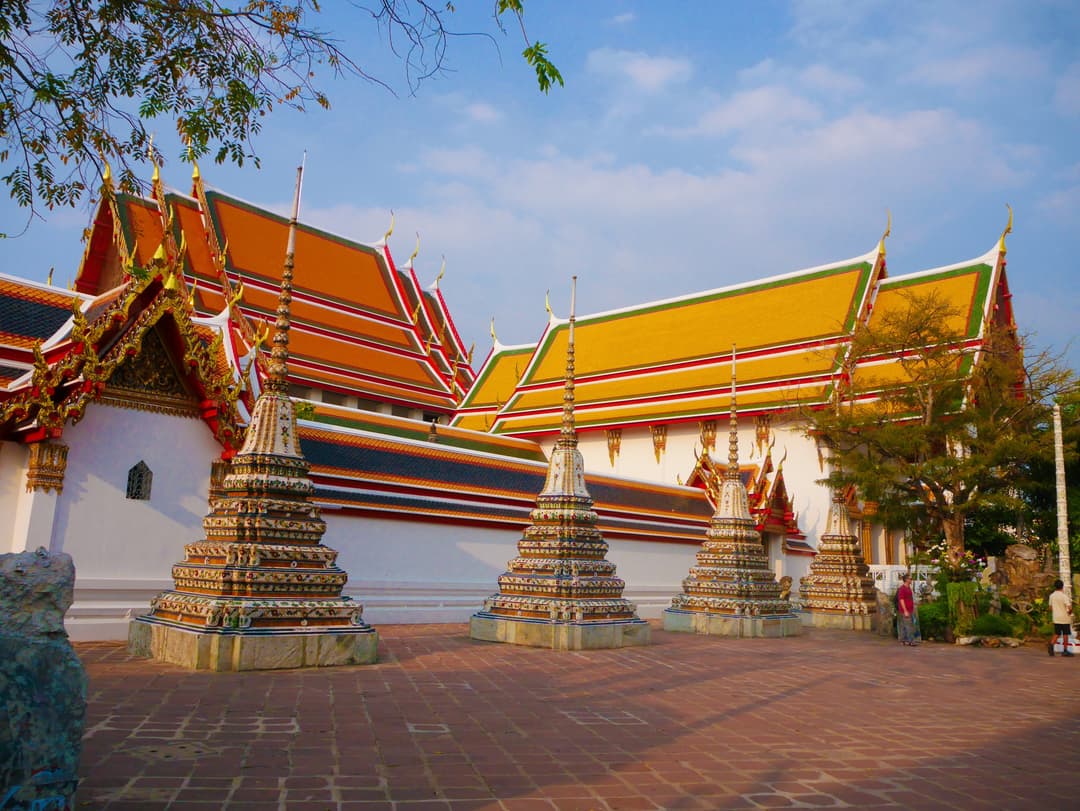 Ornate porcelain chedis in the courtyard of Wat Pho in daylight.