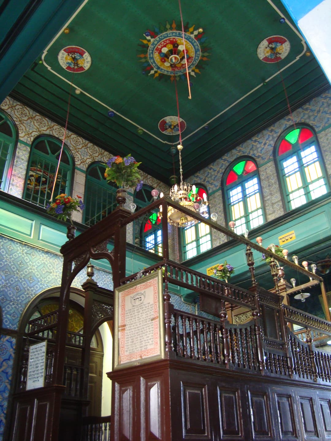 Interior view featuring the carved wooden bimah and painted ceiling