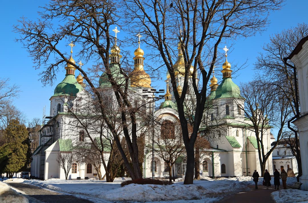 Saint Sophia Cathedral viewed across snowy grounds through bare trees.