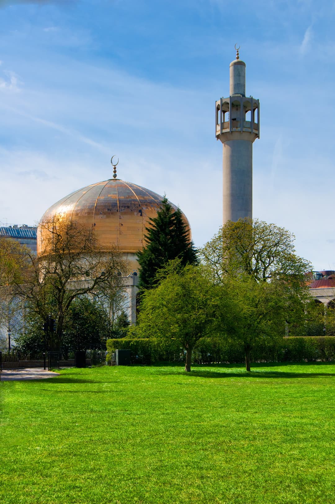 Golden dome and minaret of London Central Mosque seen across Regent's Park lawn.