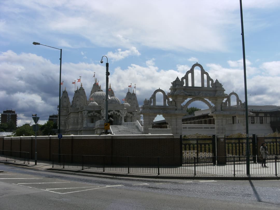 Street-level view of the Mandir's carved stone gateway and spires.