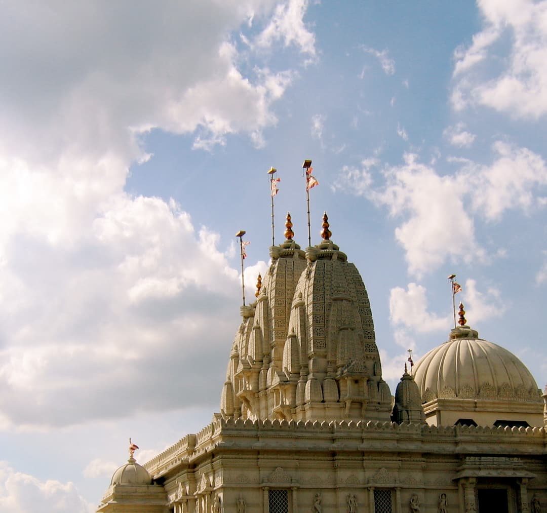 Low-angle view of the temple's carved stone spires and dome against the sky.