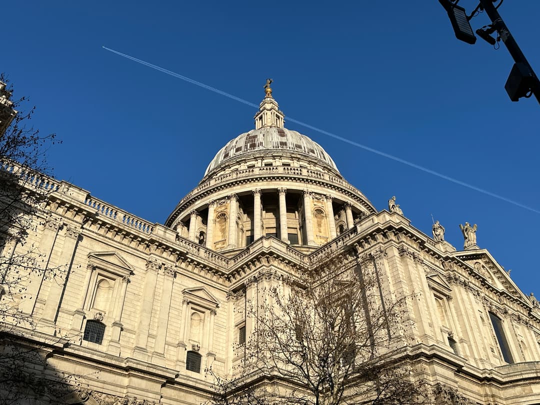 Low-angle view of St. Paul's Cathedral's iconic dome against a clear blue sky.