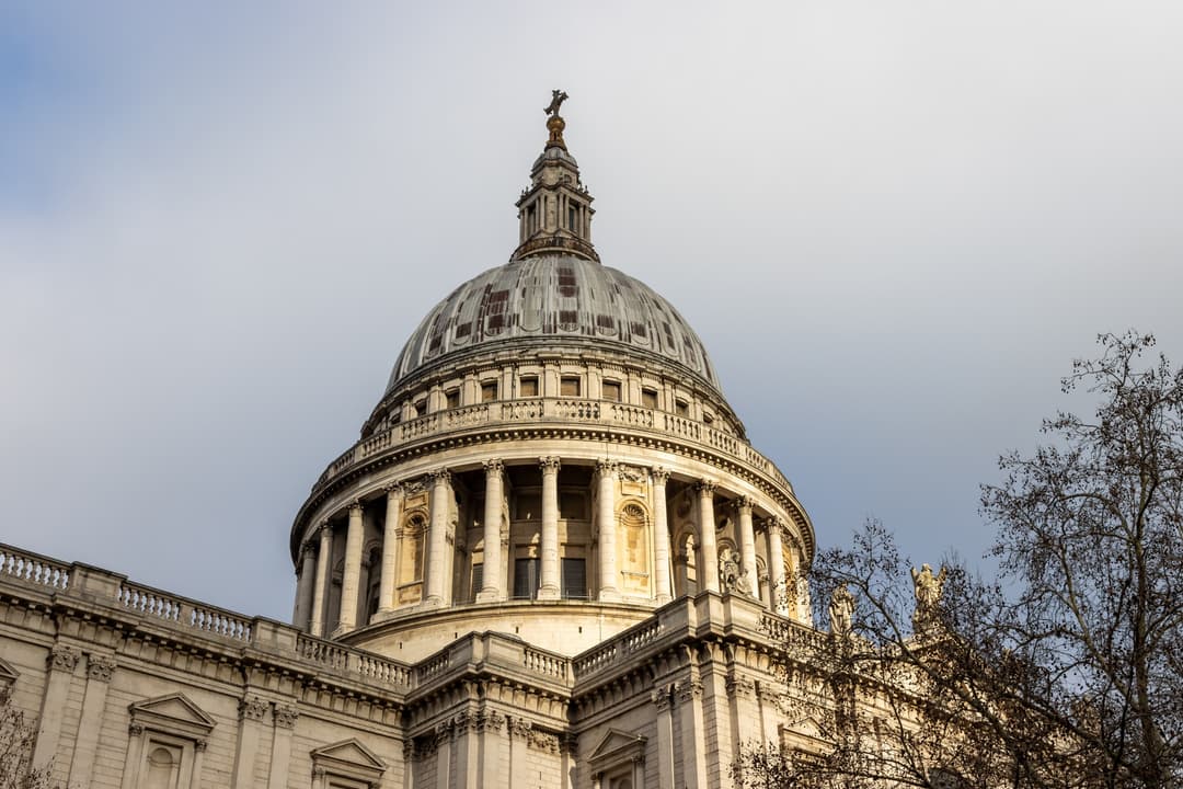 Low-angle view of the dome of St. Paul's Cathedral in warm afternoon light.