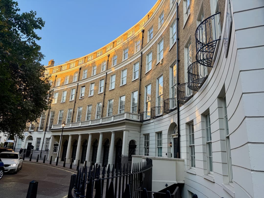 Exterior view of the curved Georgian crescent facade at golden hour.
