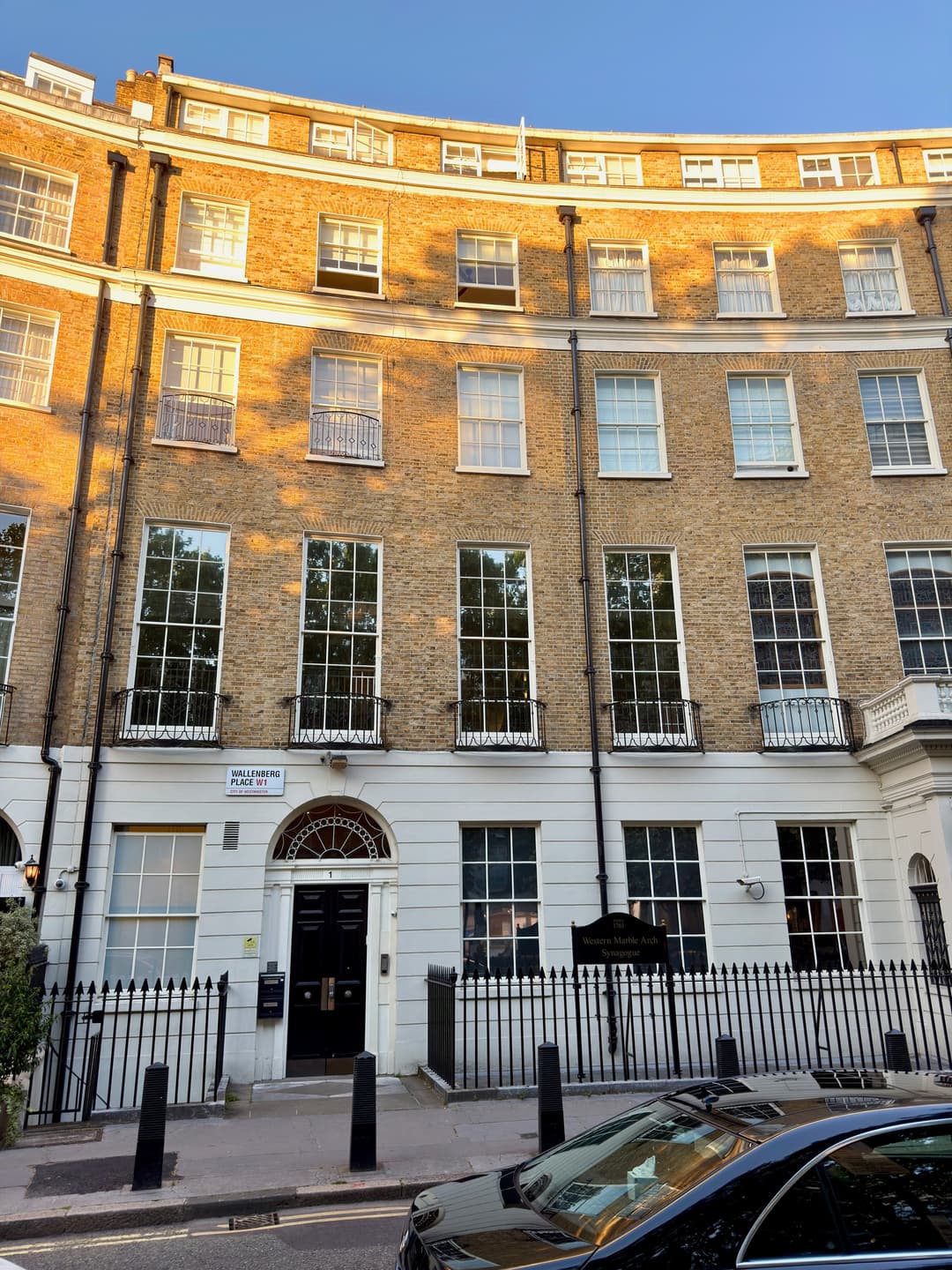 Exterior facade and entrance of 1 Wallenberg Place in warm sunlight.