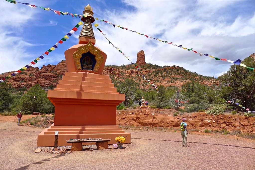 Amitabha Stupa with prayer flags against the Sedona red rock landscape.
