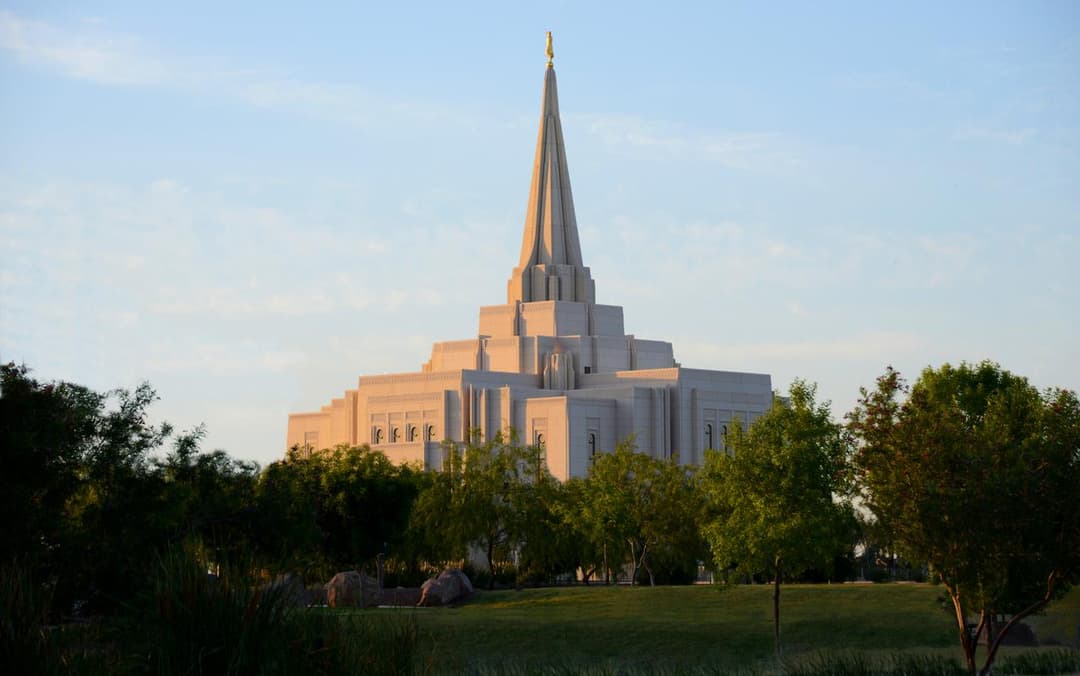 Gilbert Arizona Temple exterior at golden hour, featuring its spire and grounds.