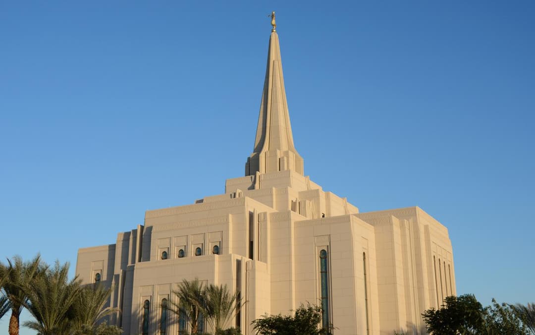 Gilbert Arizona Temple's spire and Moroni statue against blue sky.