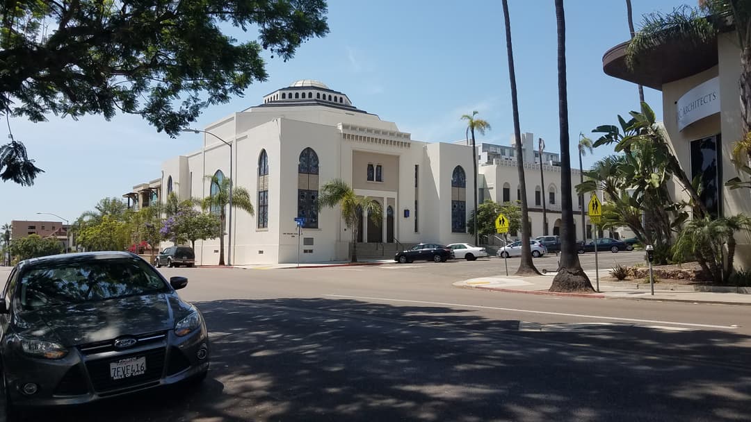Exterior street view of the domed synagogue and facade in daylight.