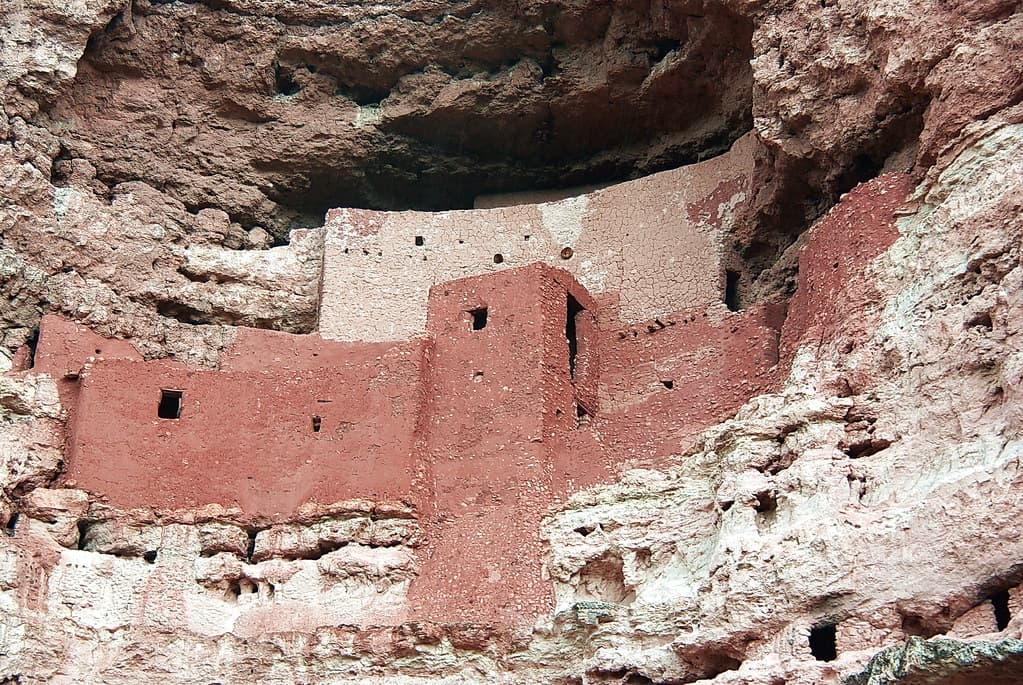 Low-angle view of Montezuma Castle built into a limestone cliff alcove.