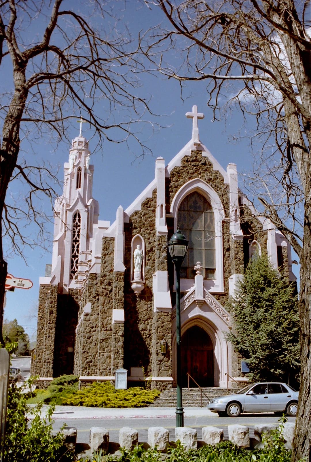 Front facade and Gothic bell tower framed by bare trees.