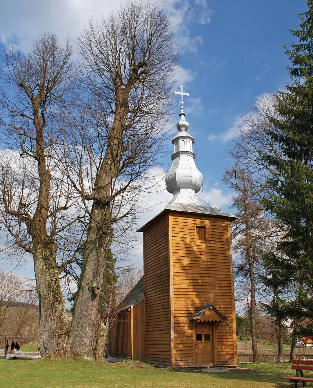 Exterior view of the wooden chapel tower with metal onion dome and cross