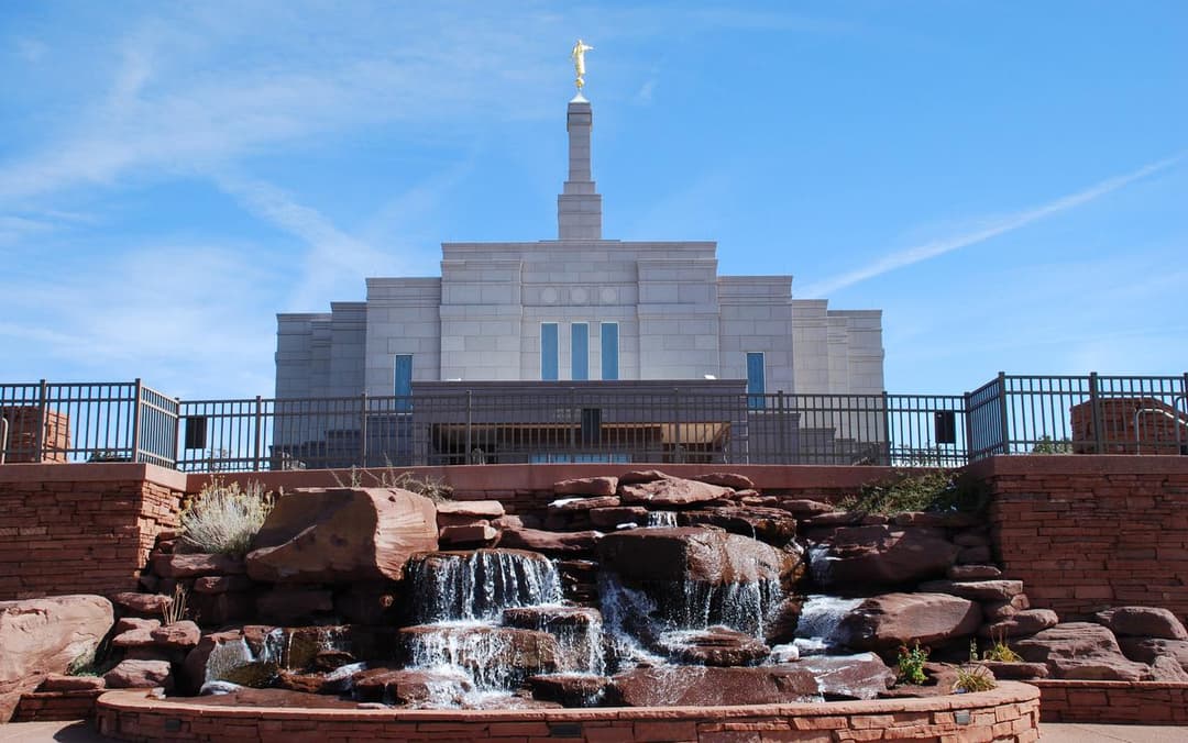 Daytime front view of the Snowflake Arizona Temple with red rock waterfall.